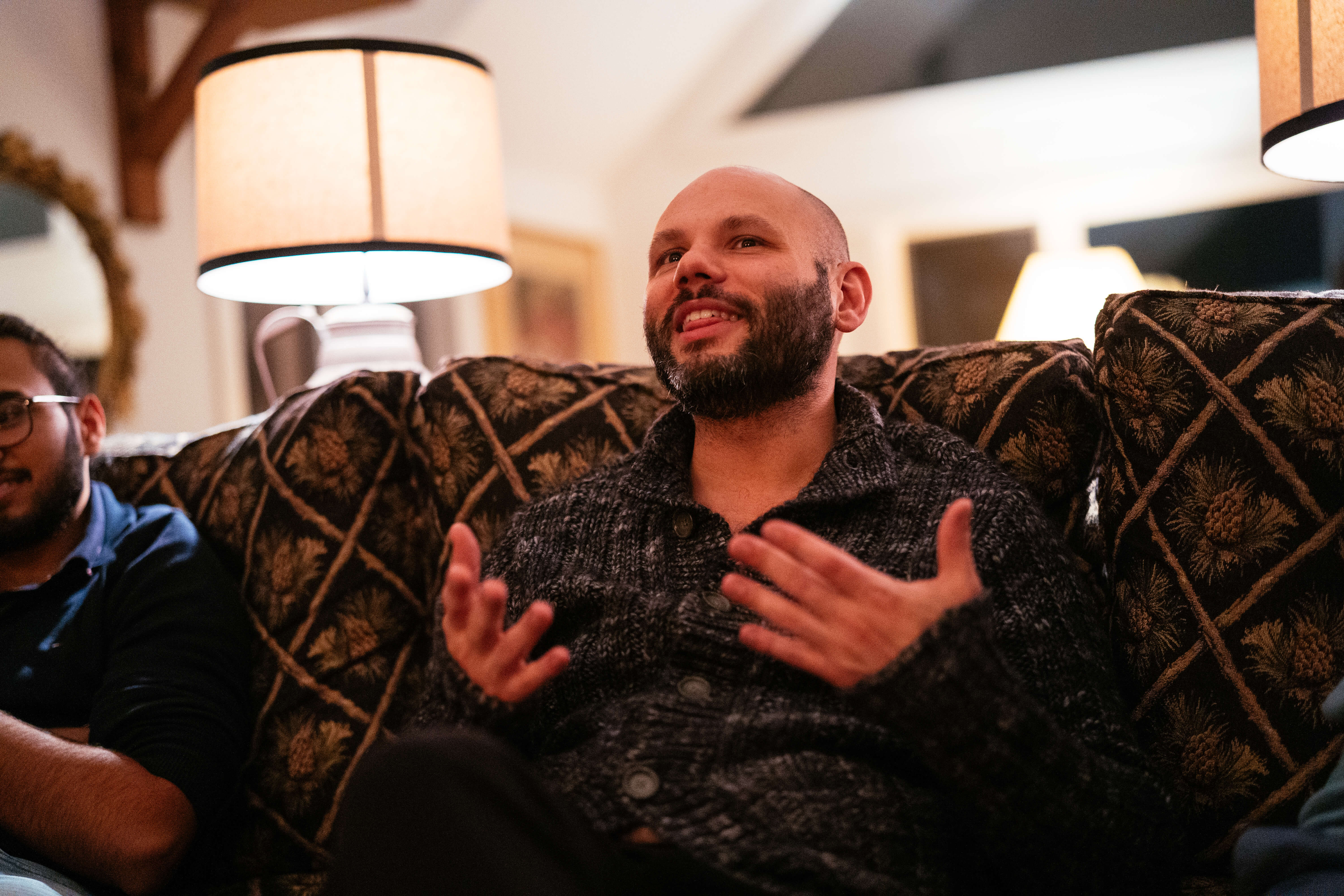 Conversation on a couch in warm lamplight
